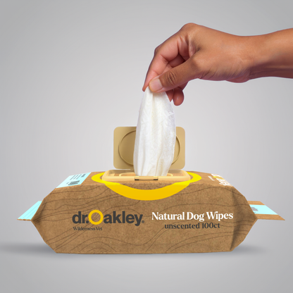 Dr. Oakley Natural Dog Wipes with a hand taking a wipe out of the box on a gray background